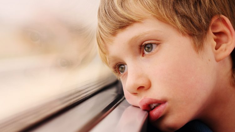 Young Boy with Head On Window Looking Outside