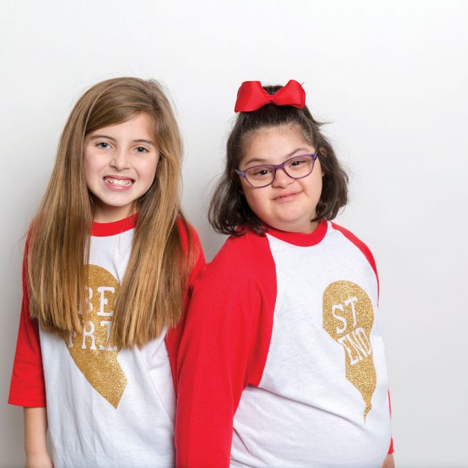 Two Young Girls Posing for Picture on White Background