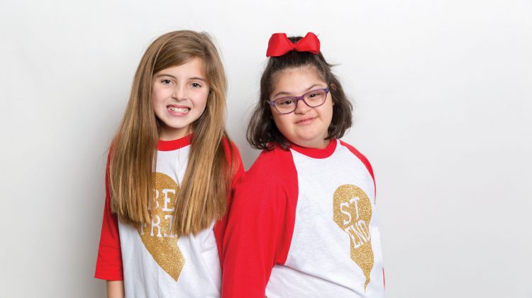 Two Young Girls Posing for Picture on White Background