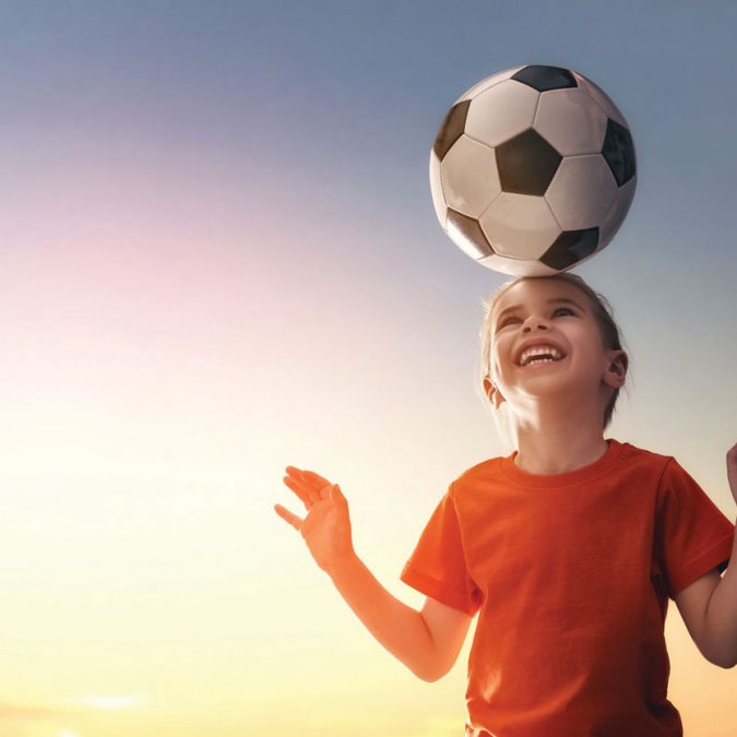 Young Girl with Soccer Ball on Her Head