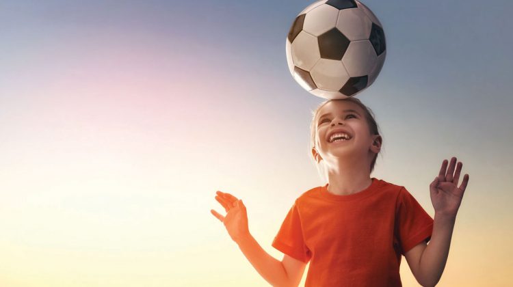 Young Girl with Soccer Ball on Her Head