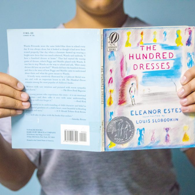 Young Boy Holding Up a Kids Book