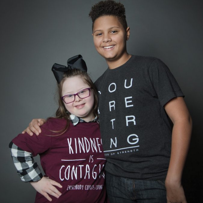 Two Friends Posing for Picture next to Black Background