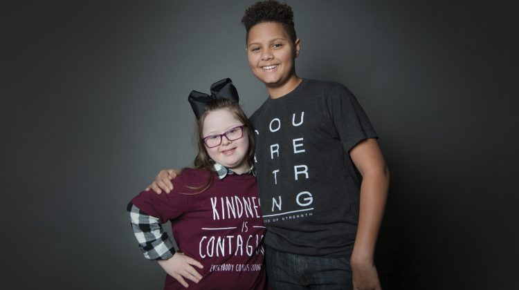 Two Friends Posing for Picture next to Black Background