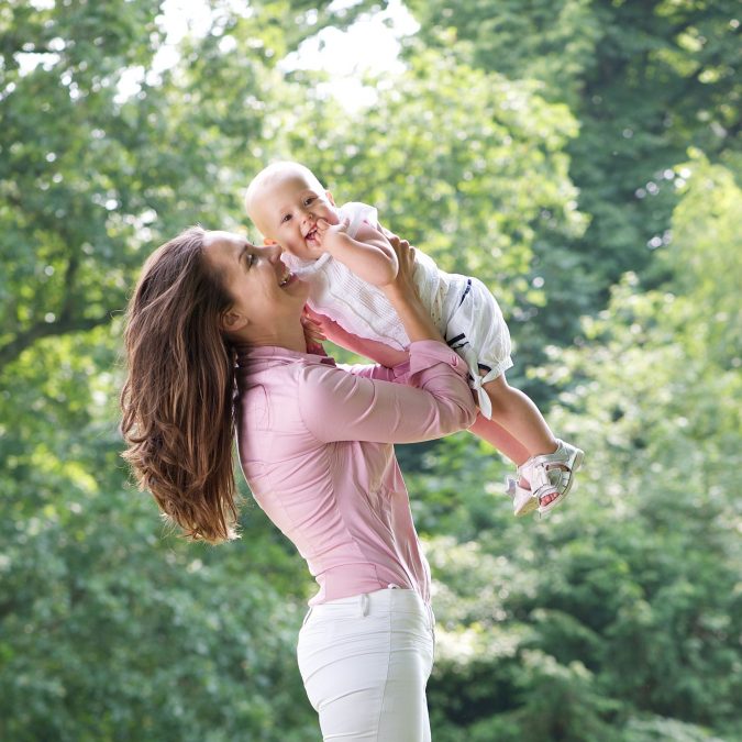 Mother Holding Her Toddler Up in the Air