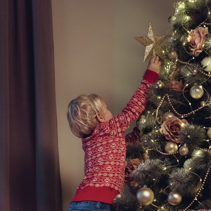 Little boy decorating Christmas tree