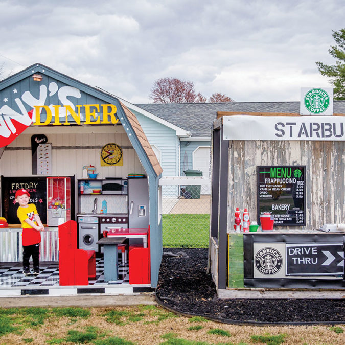 Four-year-old Tennyson Elder, posing in front of his diner and Starbucks playhouses.