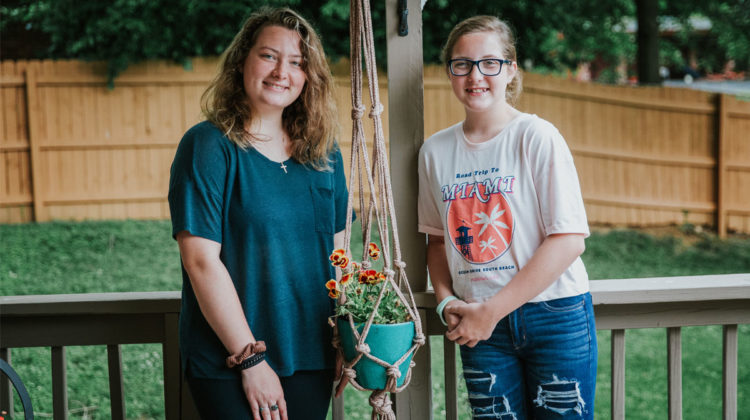 Girls smile next to their macrame pot holder