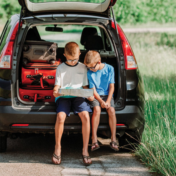 Boys looking at a map in the back of a car