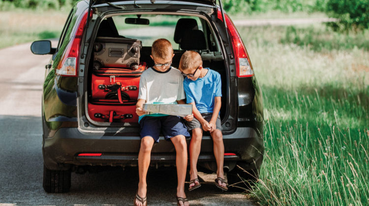 Boys looking at a map in the back of a car