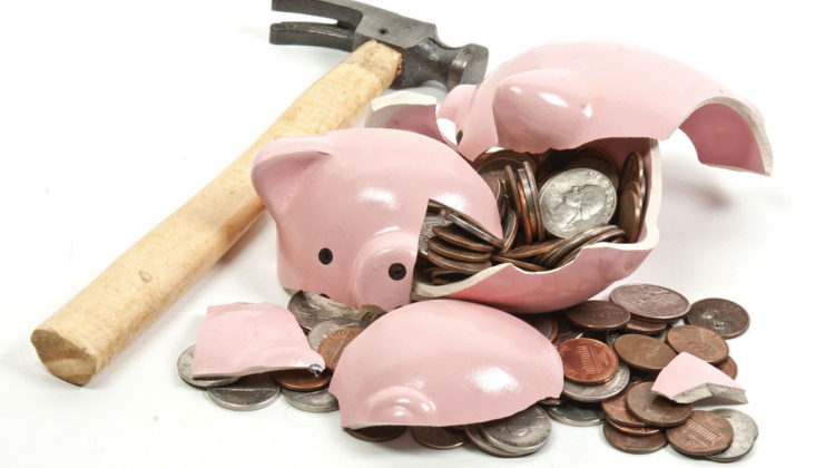 Broken piggy bank and hammer laying on white background