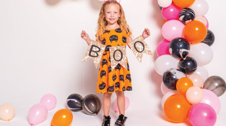 Little girl in cat ears holding "Boo" sign