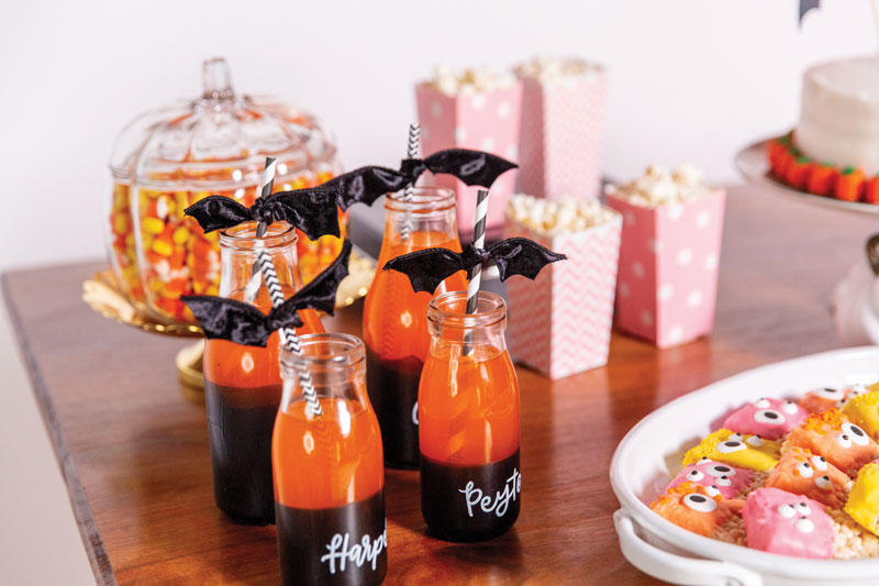 orange soda in customized glass bottles with fun straws and ribbons that look like bats