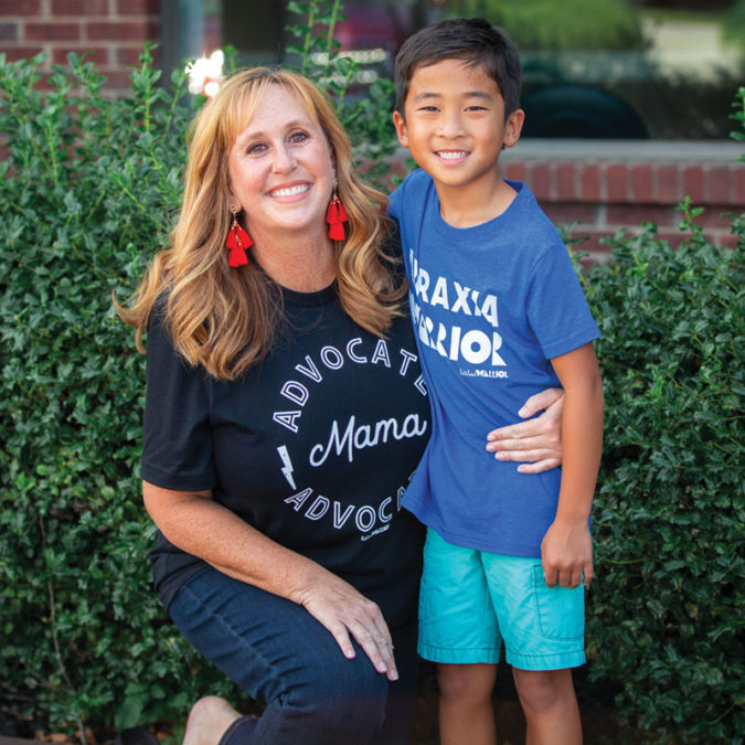 Portrait of Cathy White with her son Curtis in front of green bushes