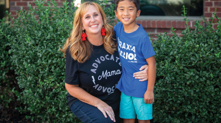 Portrait of Cathy White with her son Curtis in front of green bushes