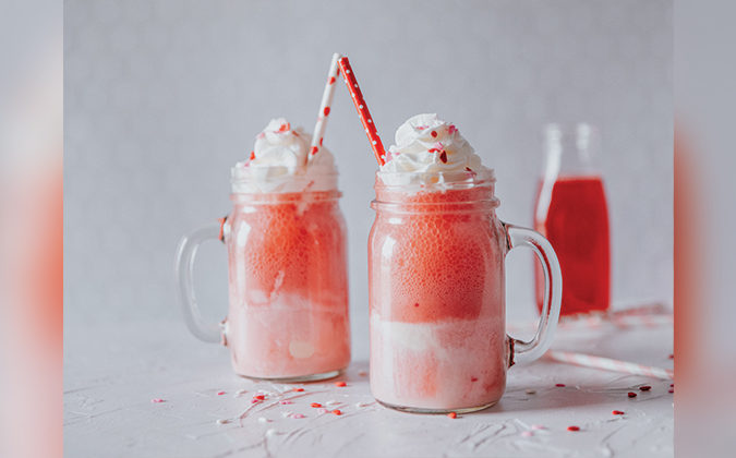 Red and pink floats with whipped cream and sprinkles