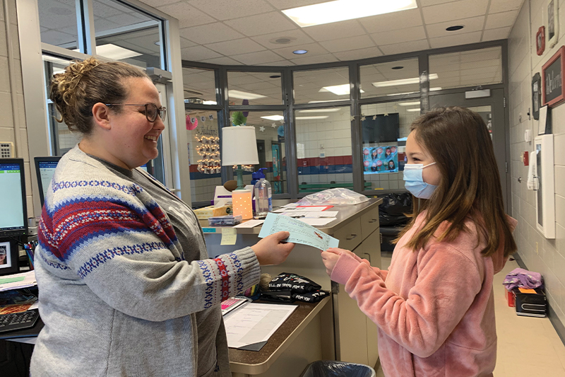 Sam Tooley, Audubon Secretary accepts an Eagle Up card from fifth grade student Violet Schwartz for showing grit and embracing diversity.